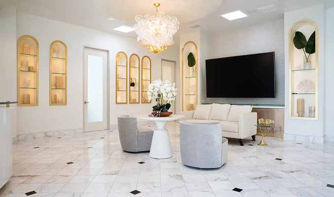 Elegant white luxury living room with marble floors, built-in shelving, modern furniture and chandelier