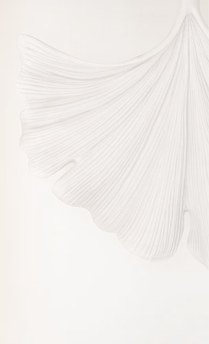 White pleated fabric draping elegantly against white background creating soft flowing lines and texture