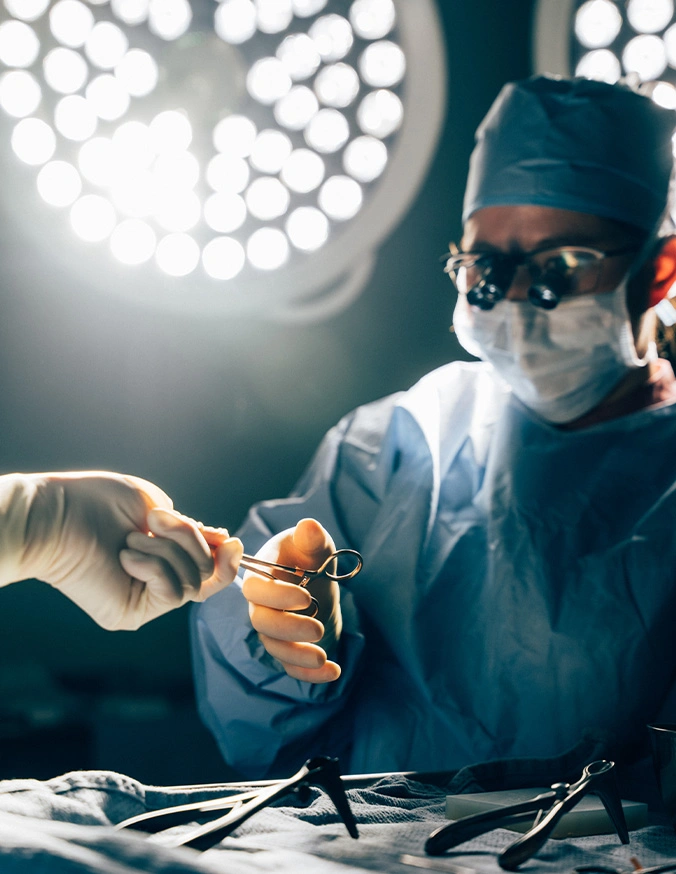 Doctor Tiffany Pham MD performing operation in operating room with surgical lights and medical instruments - eyelid surgery in San Diego, CA