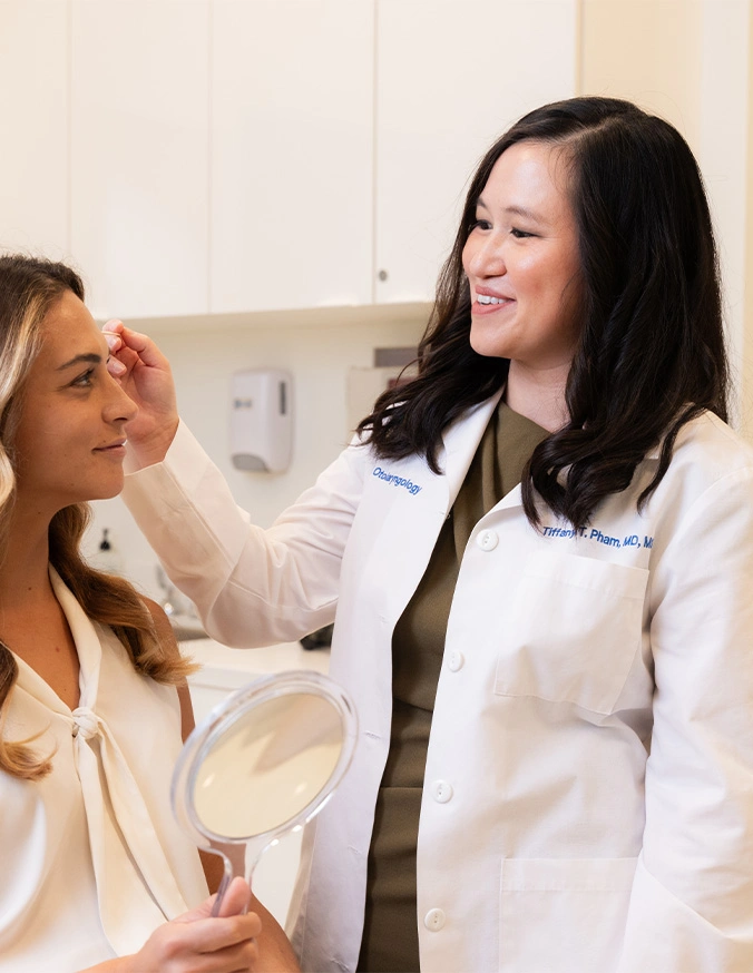 Doctor Tiffany Pham MD consulting with patient during medical examination in bright clinic office - Forehead reduction in San Diego, CA